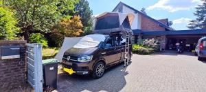 a black truck parked in a driveway with a tent on it at Büchelblick Camping in Monschau