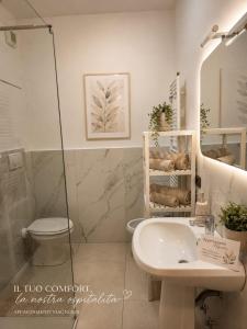a white bathroom with a sink and a toilet at Appartamento Magnolia 209 in Pomezia