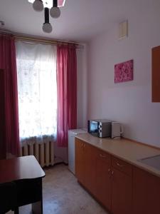 a kitchen with a microwave on a counter with a window at Hotel Uyut in Kremenchuk