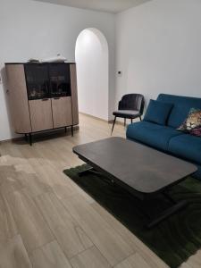a living room with a blue couch and a table at Valle du mezzane in Valle-di-Mezzana