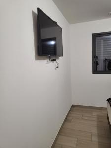 a flat screen tv hanging on a white wall at Valle du mezzane in Valle-di-Mezzana
