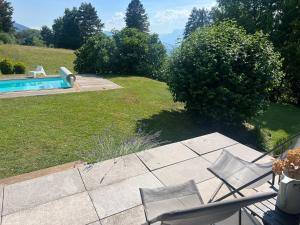 a patio with two chairs and a swimming pool at Les Angères in Saint-Martin-d'Uriage