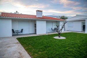 a white house with a small tree in the yard at Casa Veigas in Macedo de Cavaleiros