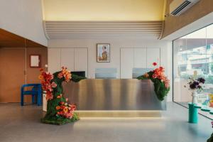a reception area with flowers on a table at Lilybeth Hotel Pratunam in Bangkok