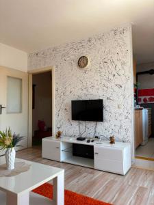 a living room with a tv on a white wall at Stan na dan in Pljevlja