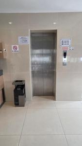 a metal elevator in a building with signs on the wall at Kampar Boutique Hotel in Kampar