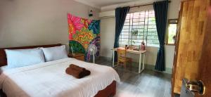 a bedroom with a bed with a teddy bear on it at Coconut Lodge in Kampot