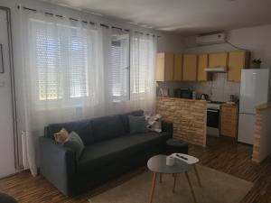 a living room with a couch and a kitchen at Apartment Laura & Lucija in Osijek