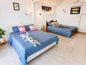 two beds in a bedroom with blue sheets at Doi Lan Home stay ดอยล้านโฮมสเตย์ in Ban Huai Khai