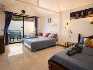 two beds in a bedroom with a view of the ocean at Doi Lan Home stay ดอยล้านโฮมสเตย์ in Ban Huai Khai +34 photos