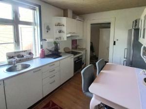 a kitchen with white cabinets and a sink and a window at Villa Sommersted Andersen in Sommersted