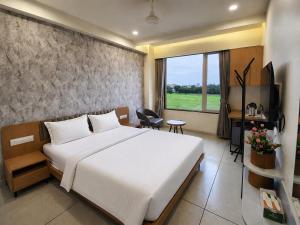 a hotel room with a bed and a television at hotel green rio in Ahmedabad