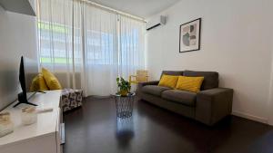 a living room with a couch and a television at The Yellow Corner in Pasian di Prato