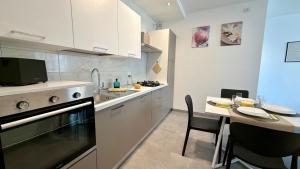 a kitchen with a stove and a table with chairs at The Yellow Corner in Pasian di Prato