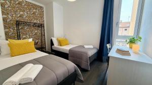 a hotel room with two beds and a window at The Yellow Corner in Pasian di Prato