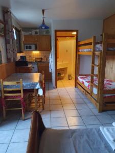 a kitchen with a dining table and bunk beds at Le Maurillon in Saint-Pancrace +56 photos