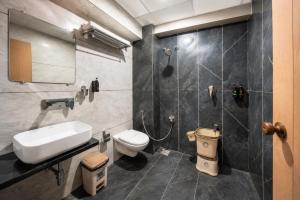 a bathroom with a shower and a toilet and a sink at hotel green rio in Ahmedabad