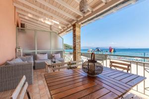 a patio with a table and a view of the ocean at Seaview stone apartment in Ipsos Beach in Ipsos