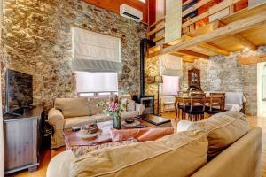 a living room with couches and a stone wall at Seaview stone apartment in Ipsos Beach in Ipsos