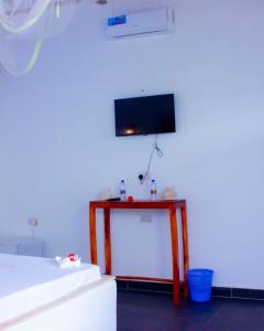 a room with a bed and a table with a tv on the wall at Datch Hideaway in Kiwengwa
