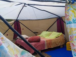 a room with a bed in a tent at La GéoYourte in Saint-Vincent