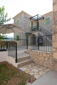 a stone building with a staircase and an umbrella at Dervisia Stonehouse 3 in Lazaráta