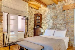a bedroom with a bed and a stone wall at Seaview stone apartment in Ipsos Beach in Ipsos