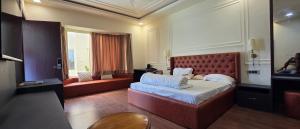 a hotel room with a bed and a couch at Parinay Pavilion LLP in Bahraich