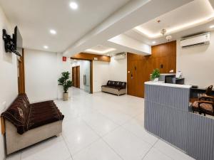 a living room with a couch and a lobby at hotel green rio in Ahmedabad