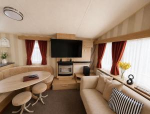a living room with a couch and a table at Seaside Escape at St Osyth in Clacton-on-Sea