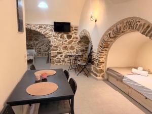 a room with a bed and a table and chairs at Mastic Ev in Chios