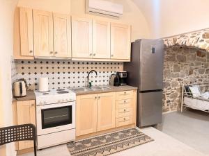 a kitchen with wooden cabinets and a stainless steel refrigerator at Mastic Ev in Chios +2 photos