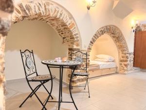 a table and two chairs in a room with a bed at Mastic Ev in Chios