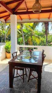 a wooden table and chairs on a patio at Lunara Sanctuary in Induruwa