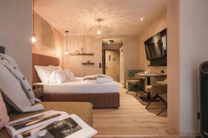 a hotel room with a bed and a living room at Hotel Sieghard Zillertal in Mayrhofen