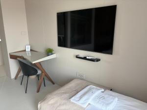 a bedroom with a bed and a desk with a tv on the wall at Vista on the sea in Ankaran