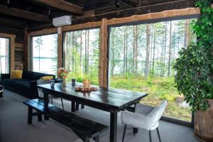 a living room with a wooden table and a large window at Elon ranta in Alvajärvi
