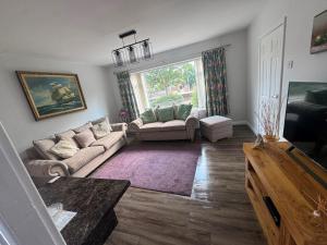 a living room with two couches and a large window at Dainville Lodge in Skegness