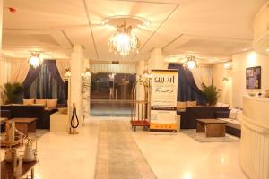 um lobby de uma loja com sofás e um lustre em Aris Furnished Apartments em Buraydah