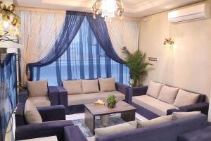 a living room with blue couches and a table at Aris Furnished Apartments in Buraydah +11 photos