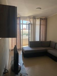 a living room with a couch and a flat screen tv at ApartamentAbiBank in Elbasan