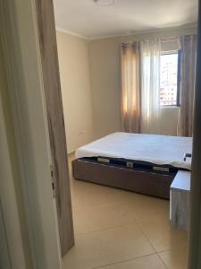 a bedroom with a bed and a window at ApartamentAbiBank in Elbasan