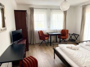 a hotel room with a bed and a table and chairs at Gästehaus Helbighof in Neustadt an der Weinstraße