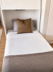 a bed in a small room with a pillow on it at Nordhaven Sundbyberg in Sundbyberg