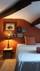a bedroom with a bed and a table with a lamp at Le Manivert in Vitry-Laché