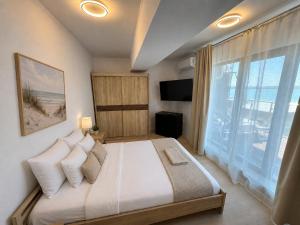 a bedroom with a large bed and a large window at Sea Gem Mamaia - 200m to Beach, XL Terrace, and Beautiful Views in Mamaia