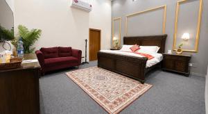a bedroom with a bed and a chair and a rug at Royal Palm Villa in Rawalpindi