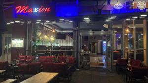 a restaurant with red chairs and a bar at Maxim City Apartment in Mainz