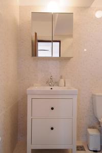 a bathroom with a white sink and a mirror at Sea Gem Mamaia - 200m to Beach, XL Terrace, and Beautiful Views in Mamaia