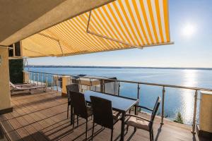 a balcony with a table and chairs and a view of the water at Sea Gem Mamaia - 200m to Beach, XL Terrace, and Beautiful Views in Mamaia